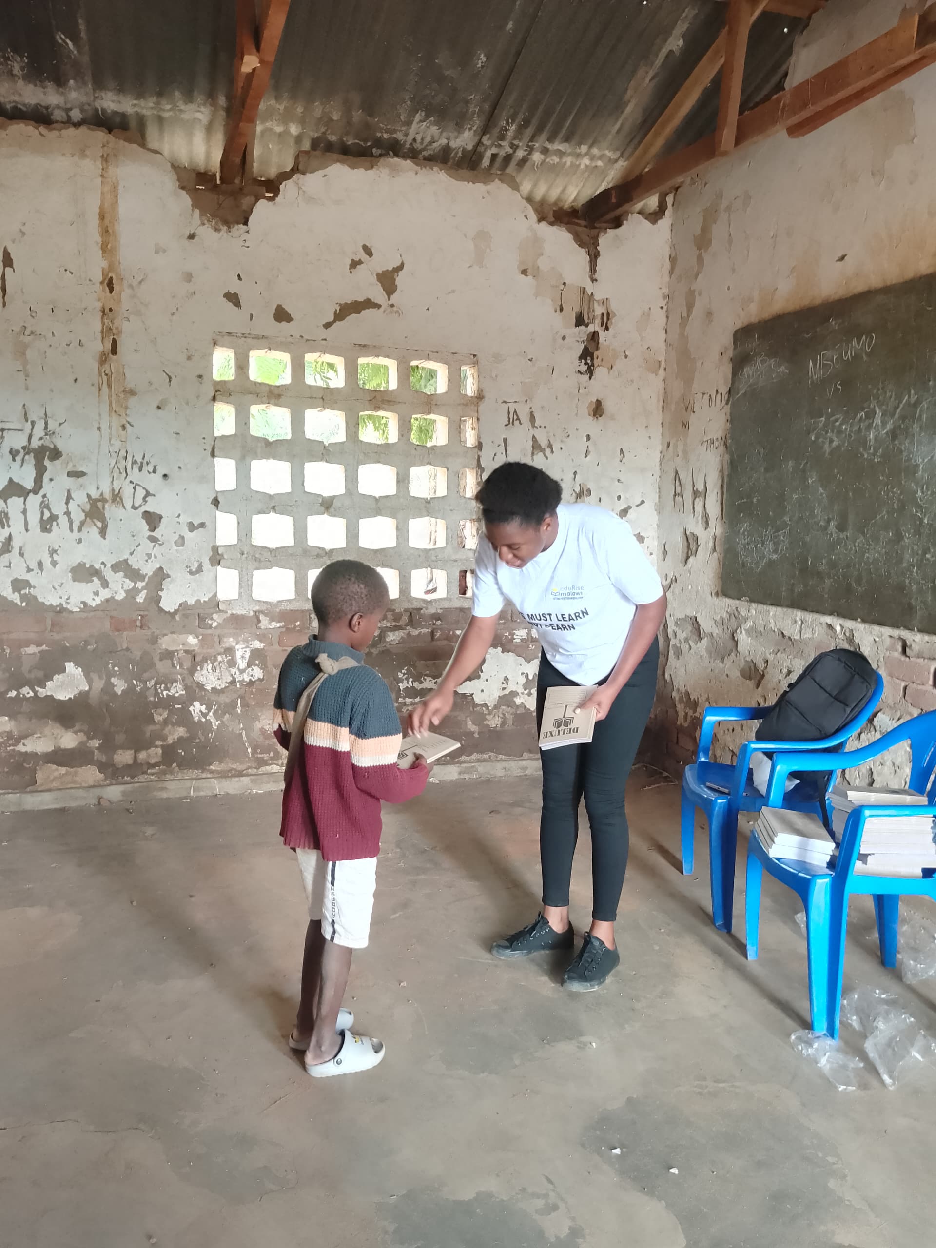 Staff helping boy with school supplies in classroom