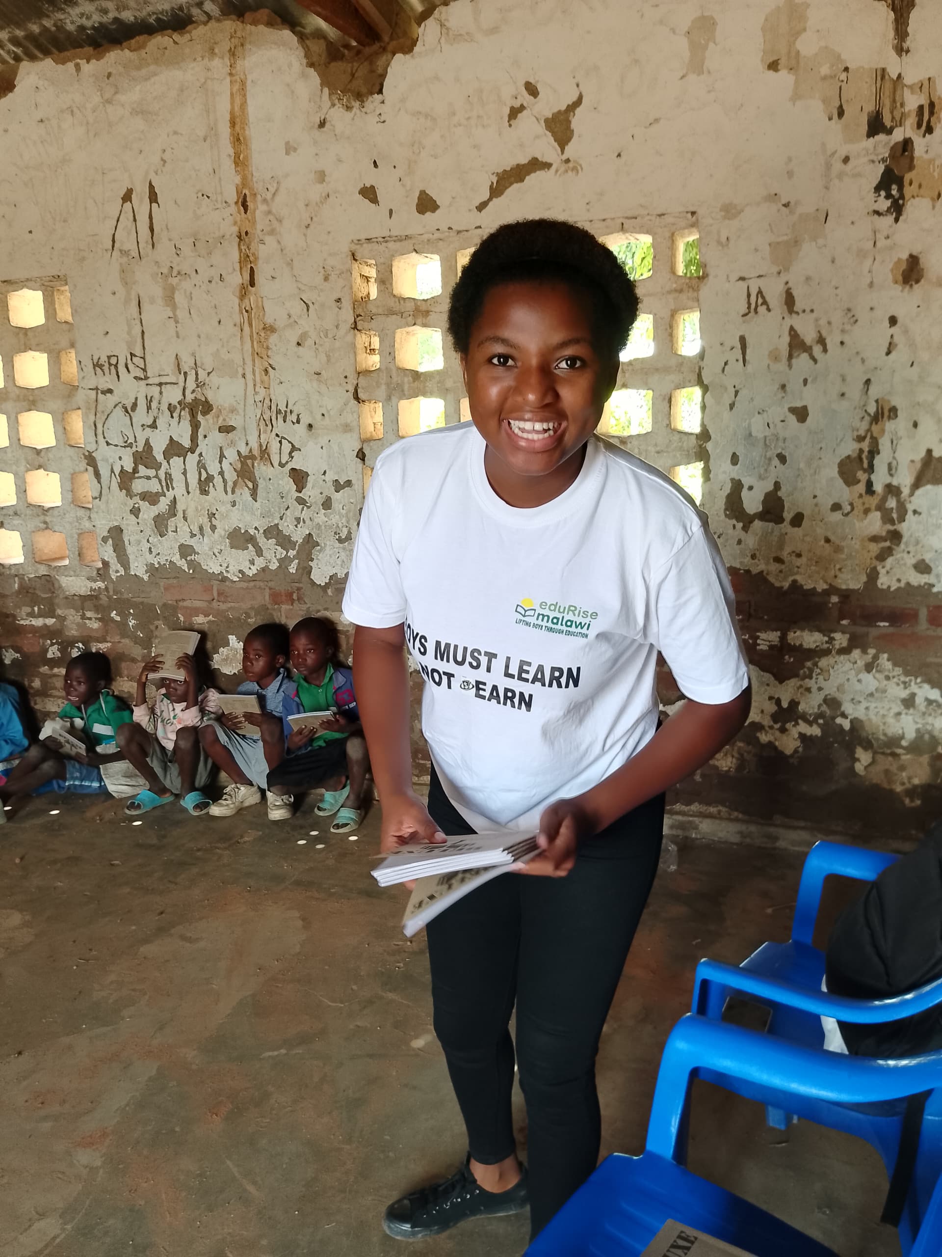 Smiling EduRise volunteer holding educational materials