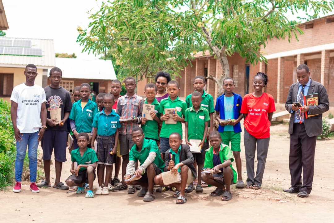 Group photo of students and staff with educational materials